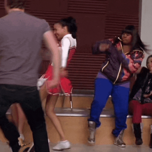 a group of cheerleaders are dancing in front of a crowd