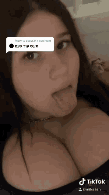a woman is sticking her tongue out in a reply to deess34 's comment on tiktok