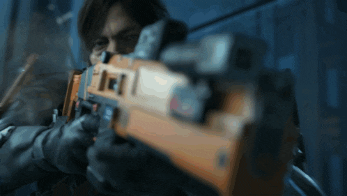a close up of a man holding a gun with the letter f on the front