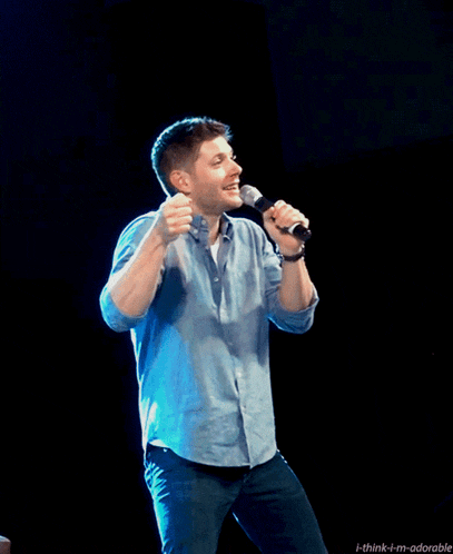 a man singing into a microphone with the words think-i-m-adorable above him