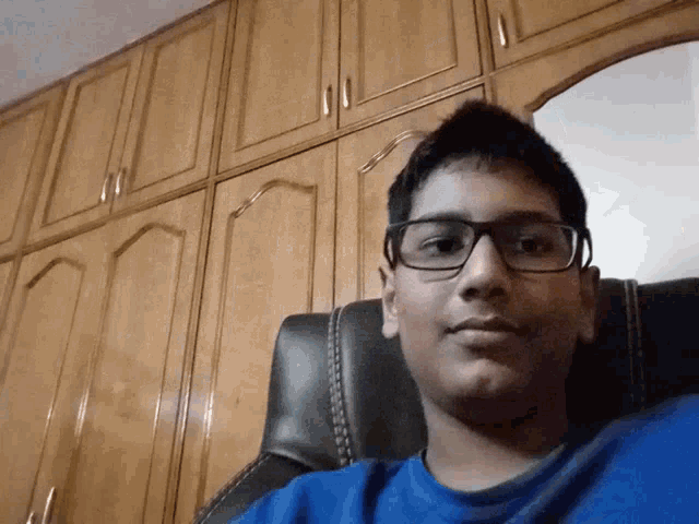 a man wearing glasses is upside down in front of a closet