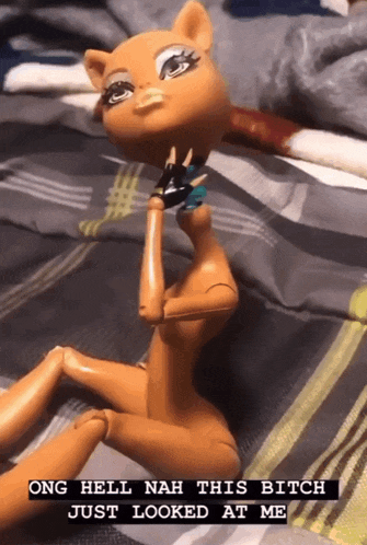 a doll laying on a bed with the words ong hell nah this bitch just looked at me