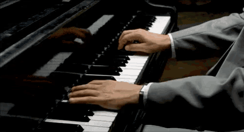 a man is playing a piano with his hands on the keys