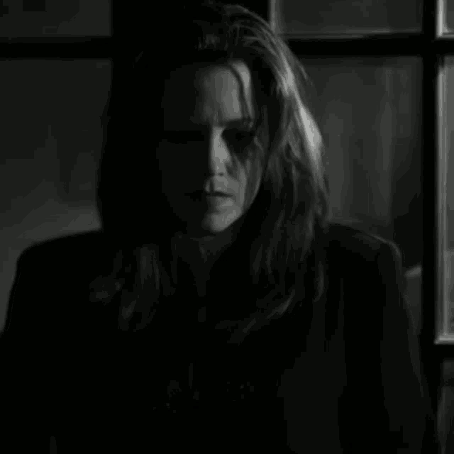 a black and white photo of a woman in a dark room