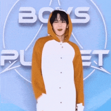 a young man in a hoodie stands in front of a boys planet logo