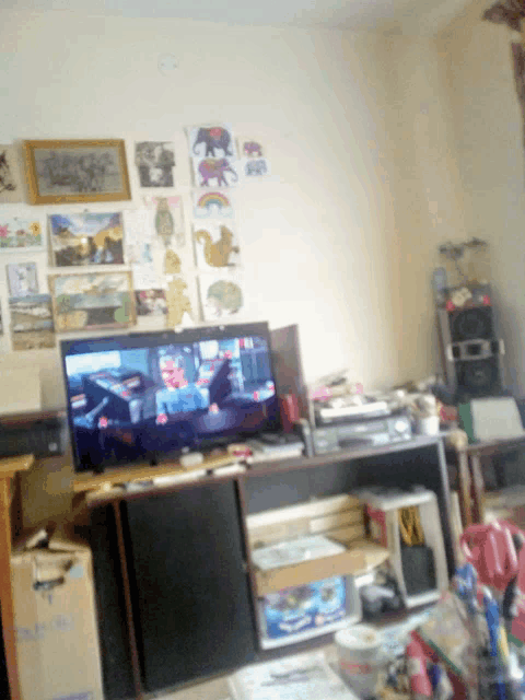 a tv is sitting on a shelf in a room with paintings on the wall