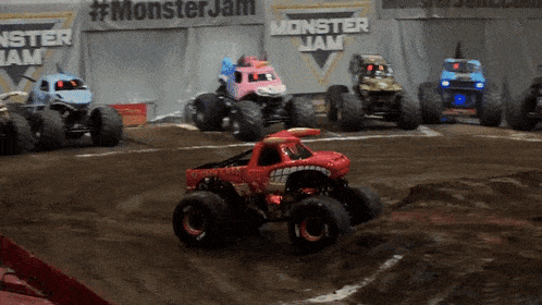 several monster jam trucks are on a track
