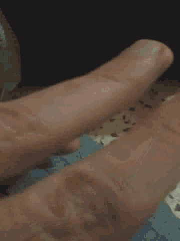 a close up of a person 's hand reaching out towards a wall .