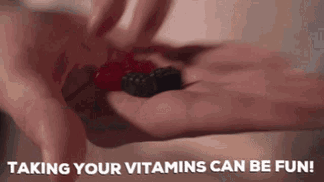 a person is holding a gummy bear in their hand and the words taking your vitamins can be fun