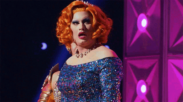 a drag queen wearing a blue sequined dress and a tiara