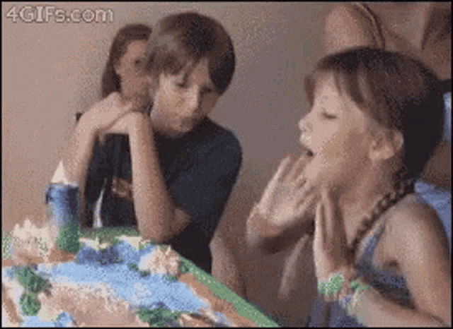 a girl blowing out a candle on a birthday cake with 4gifs.com written on the bottom