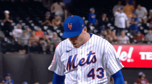 a baseball player wearing a mets jersey and hat