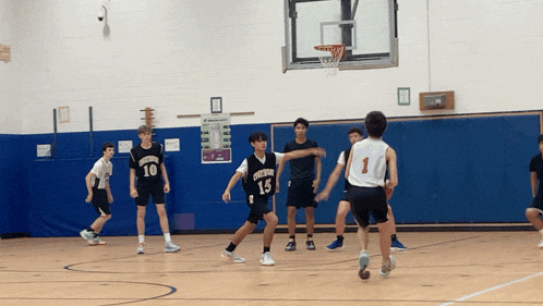 a group of boys are playing basketball and one of the players has the number 13 on his jersey