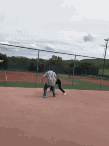 a man in a plaid shirt is standing next to a woman on a tennis court