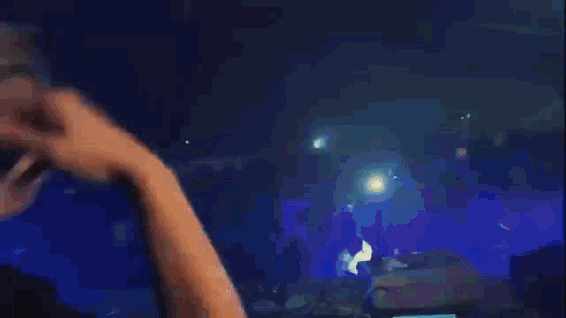 a blurry picture of a crowd at a concert with a blue background