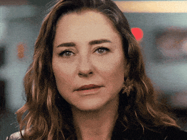 a close up of a woman 's face with a serious expression