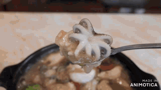 a spoon with an octopus on it and the words made in animotica on the bottom right