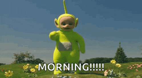 a yellow teletubbies character is standing in a field of flowers and says morning .