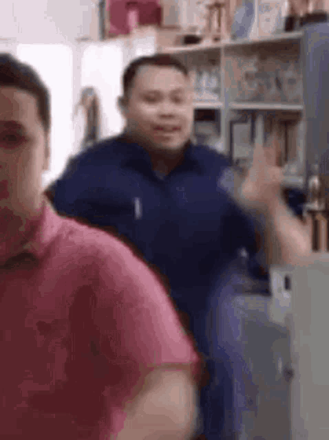 two men are standing next to each other in a room .