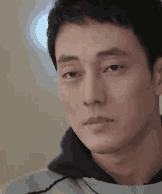 a close up of a man 's face with a hood on