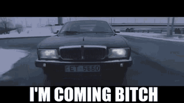 a car is driving down a snowy road and the words `` i 'm coming bitch '' are written on the bottom