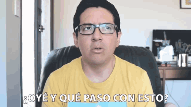 a man wearing glasses and a yellow shirt says " oy y que paso con esto "