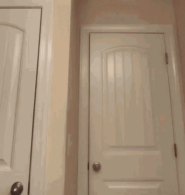 a white door is open to a dark room in a house