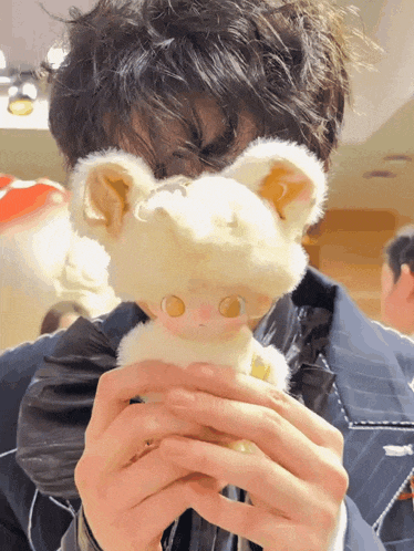 a person holding a stuffed animal in front of their face with a yellow eye