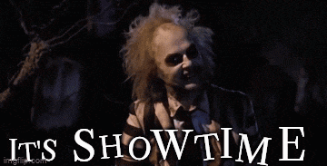 a man in a striped shirt says it 's showtime in front of a graveyard .