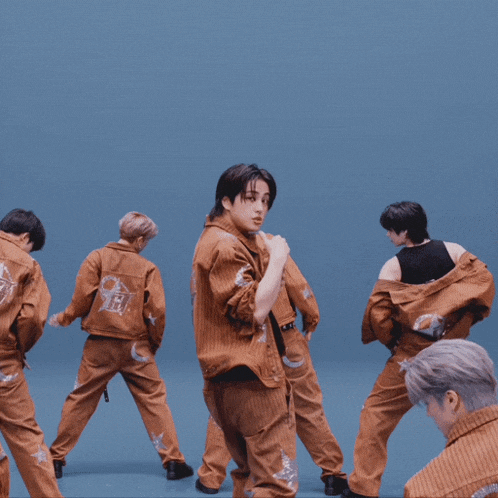 a group of young men are dancing on a blue stage