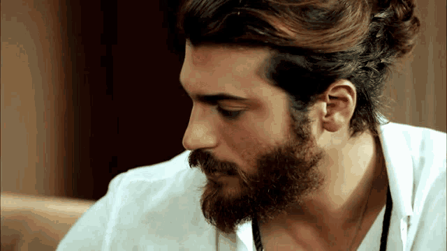 a man with a beard wearing a white shirt