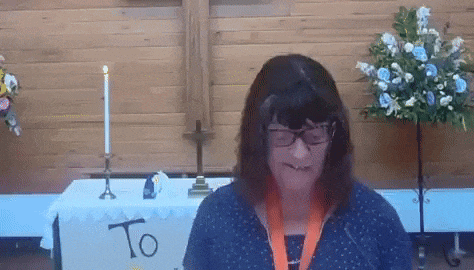 a woman wearing glasses is standing in front of a table with the word to on it