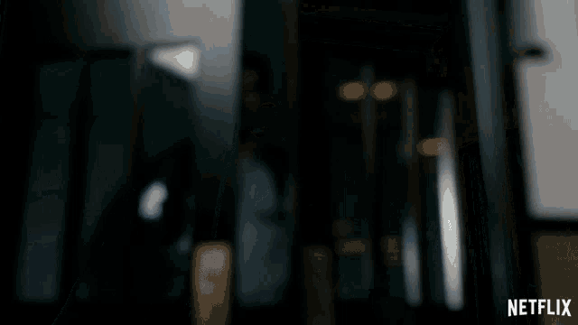 a man in a suit stands in front of a door that says netflix on the bottom