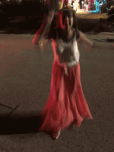 a woman in a pink dress is walking down the street