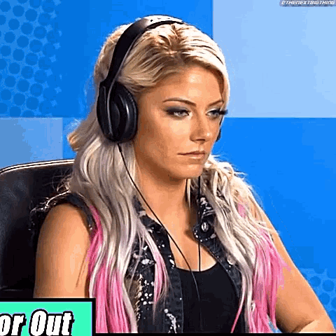 a woman wearing headphones is sitting in front of a sign that says or out