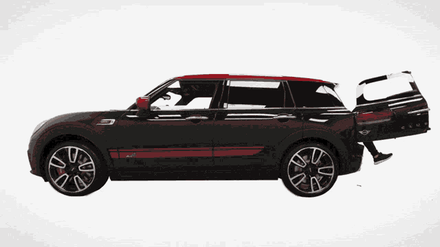 a black mini cooper with a red stripe on the side is being pushed by two people
