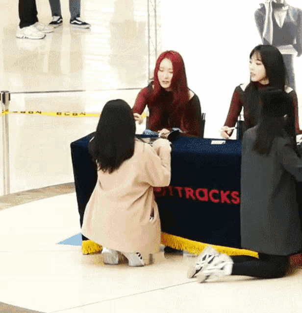 a woman kneeling in front of a table that says tracks on it