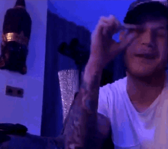 a man with a tattoo on his arm is making a peace sign with his hands