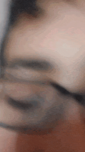 a blurry picture of a person 's face with glasses on