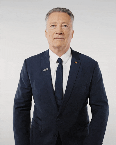a man in a suit and tie applauds with both hands