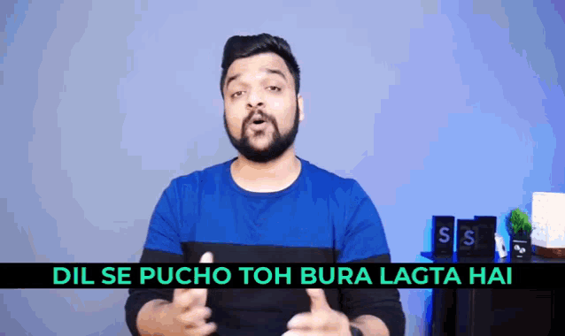 a man in a blue shirt is giving a thumbs up with the words dil se pucho toh bura lagta hai below him