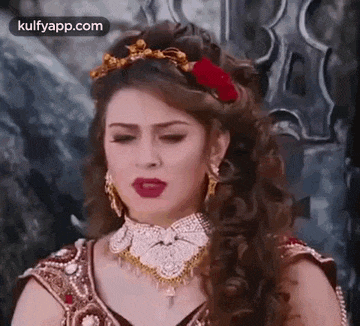 a woman with long hair and a crown on her head is wearing a necklace .