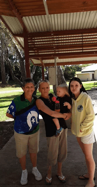 a group of people posing for a picture including one wearing a shirt that says ' hawaii ' on it