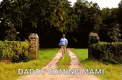 a man is walking down a dirt road with the words daddy coming mami written on the bottom .