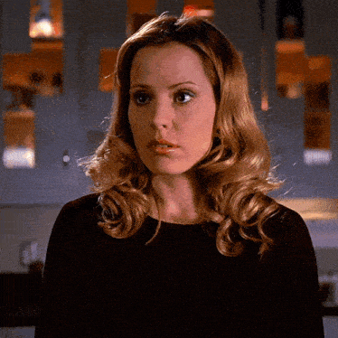 a woman with blonde hair wearing a black shirt