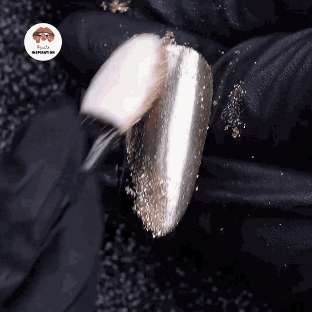 a close up of a nail with a black glove behind it that says rude inspiration on it