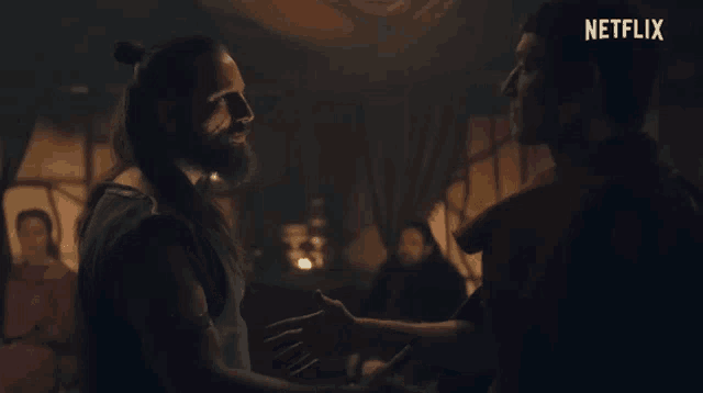 two men are shaking hands in a dark room with a netflix logo on the bottom