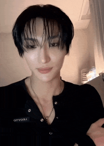 a close up of a person wearing a black shirt with a necklace that says otyo3j on it