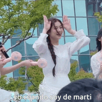 a woman in a white dress is dancing in front of a crowd with yo cuando soy de marti written on the bottom