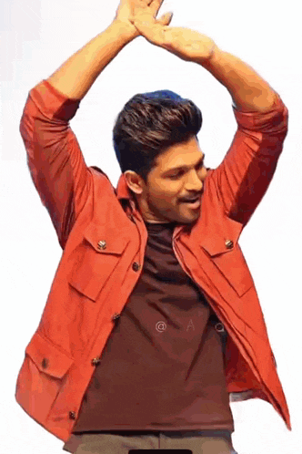 a man in a red jacket is dancing with his arms up